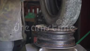由机械师修理汽车爆胎. 在换胎器的帮助下，从合金车轮上取出轮胎的过程